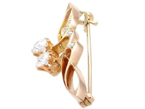 fig 2. An antique 14ct yellow gold Art Nouveau bar brooch featuring openwork whiplash curves set with accent diamonds and two suspended claw-set diamonds.