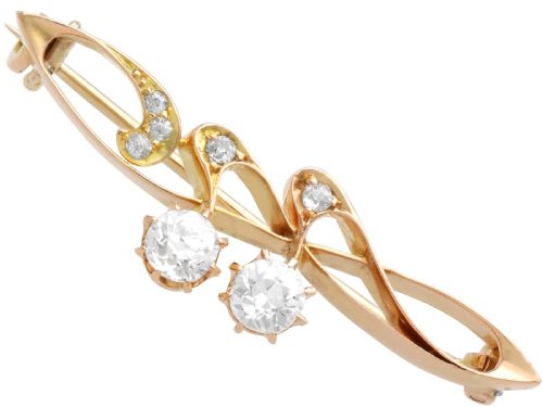 fig 3. An antique 14ct yellow gold Art Nouveau bar brooch featuring openwork whiplash curves set with accent diamonds and two suspended claw-set diamonds.