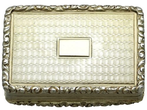 fig 1. A rectangular sterling silver gilt vinaigrette featuring an embossed scene of architectural ruins surrounded by a scrolling border.
