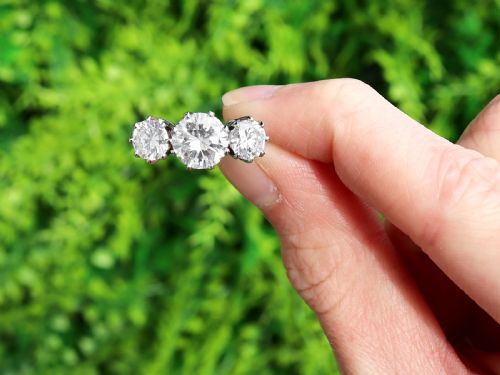fig 1. A platinum trilogy ring featuring three round brilliant cut diamonds set in individual multi-claw settings along a polished platinum band.