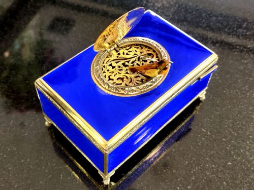 fig 2. A rectangular cobalt blue guilloche enamel and silver-gilt singing bird box with an engraved oval hatch cover and tiny cabriole feet.