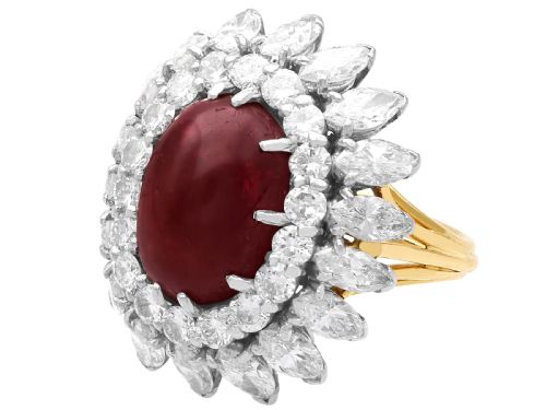 fig 4. A vintage 18ct yellow gold ring featuring a central oval cabochon red ruby surrounded by a double tiered cluster halo of diamonds.