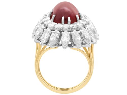 fig 6. A vintage 18ct yellow gold ring featuring a central oval cabochon red ruby surrounded by a double tiered cluster halo of diamonds.