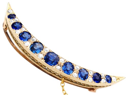 fig 3. A crescent moon brooch set with graduated blue sapphires and accent diamonds in nine-carat yellow gold with an attached safety chain.