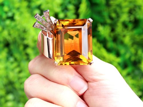 fig 1. A large emerald-cut amber citrine stone set in a 14ct yellow gold brooch mounting accented with baguette diamonds.