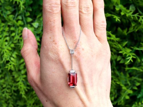 fig 1. An Art Deco 18ct white gold pendant featuring a rectangular step-cut red tourmaline suspended from a bar link set with accent diamonds.