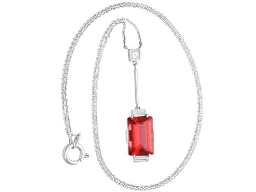 fig 2. An Art Deco 18ct white gold pendant featuring a rectangular step-cut red tourmaline suspended from a bar link set with accent diamonds.