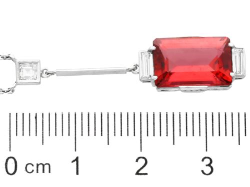 fig 5. An Art Deco 18ct white gold pendant featuring a rectangular step-cut red tourmaline suspended from a bar link set with accent diamonds.