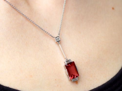 fig 8. An Art Deco 18ct white gold pendant featuring a rectangular step-cut red tourmaline suspended from a bar link set with accent diamonds.