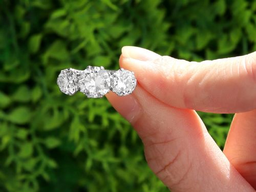 fig 1. A vintage platinum ring featuring three large round brilliant cut diamonds set horizontally in claw settings.