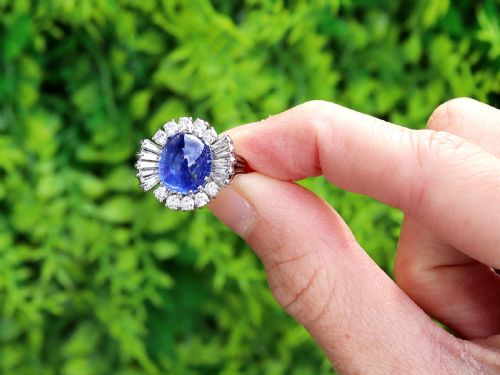 fig 1. A vintage 18ct white gold cluster ring featuring a central oval cabochon blue sapphire framed by brilliant-cut and baguette-cut diamonds.