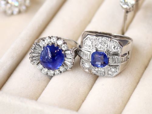 fig 3. A vintage 18ct white gold cluster ring featuring a central oval cabochon blue sapphire framed by brilliant-cut and baguette-cut diamonds.