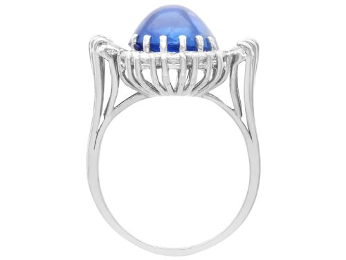 fig 6. A vintage 18ct white gold cluster ring featuring a central oval cabochon blue sapphire framed by brilliant-cut and baguette-cut diamonds.