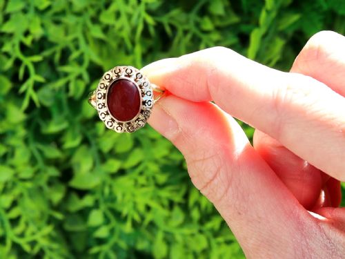 fig 1. A vintage 18ct yellow gold dress ring set with a central oval cabochon garnet encircled by an openwork gold pattern border.