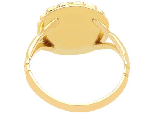 fig 4. A vintage 18ct yellow gold dress ring set with a central oval cabochon garnet encircled by an openwork gold pattern border.