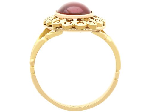 fig 5. A vintage 18ct yellow gold dress ring set with a central oval cabochon garnet encircled by an openwork gold pattern border.