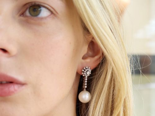 fig 2. A pair of 18ct white gold drop earrings featuring round South Sea pearls suspended from articulated diamond stems and floral cluster stud tops.