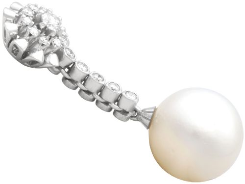 fig 5. A pair of 18ct white gold drop earrings featuring round South Sea pearls suspended from articulated diamond stems and floral cluster stud tops.