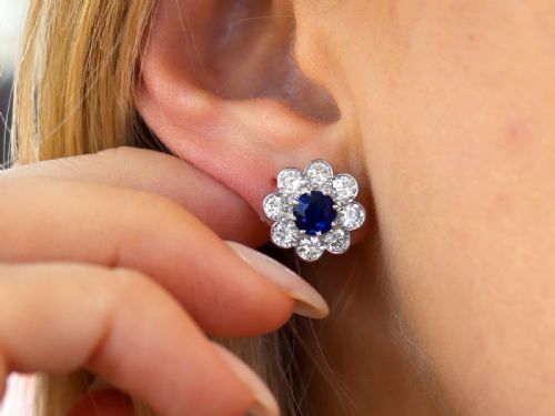 fig 2. A pair of antique floral-shaped cluster earrings featuring central round blue sapphires encircled by bright diamonds.