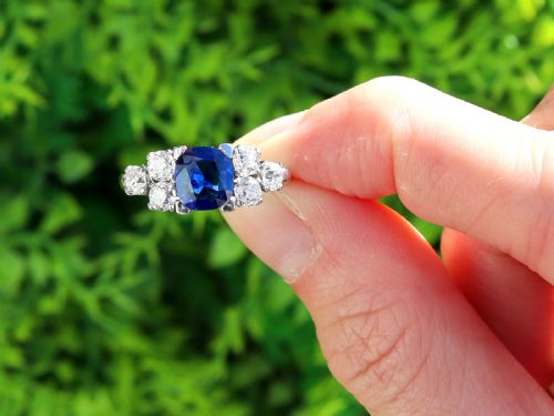 fig 1. An Art Deco platinum ring featuring a central cushion-cut blue sapphire flanked by three round diamonds on each shoulder.