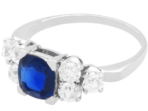 fig 2. An Art Deco platinum ring featuring a central cushion-cut blue sapphire flanked by three round diamonds on each shoulder.