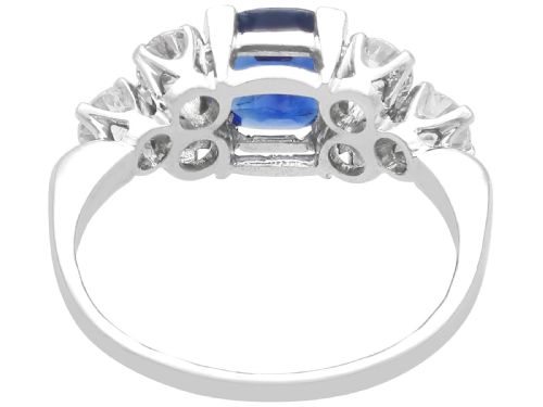 fig 3. An Art Deco platinum ring featuring a central cushion-cut blue sapphire flanked by three round diamonds on each shoulder.
