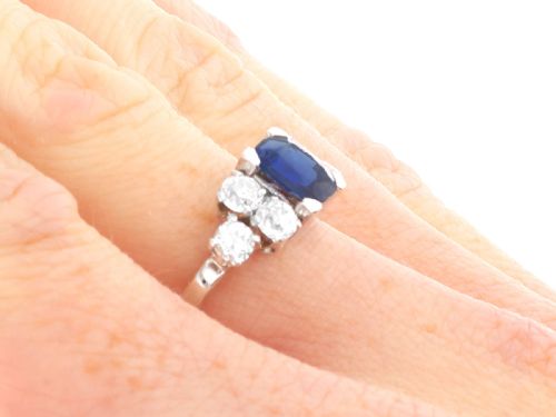 fig 6. An Art Deco platinum ring featuring a central cushion-cut blue sapphire flanked by three round diamonds on each shoulder.