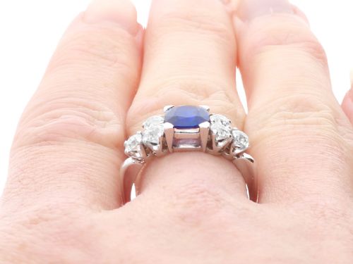 fig 7. An Art Deco platinum ring featuring a central cushion-cut blue sapphire flanked by three round diamonds on each shoulder.