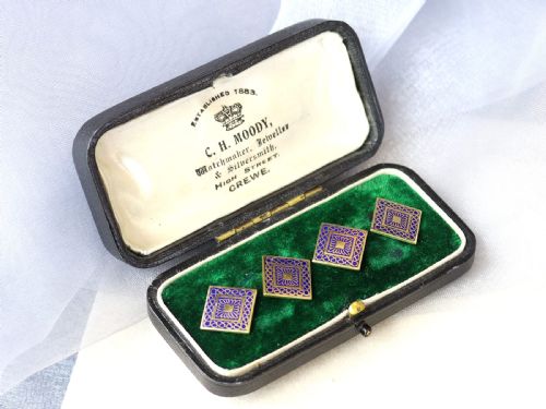 fig 3. A set of four square 18ct yellow gold cufflinks decorated with blue enamel geometric patterns, presented inside a fitted black box.