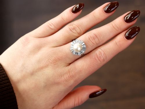 fig 2. A platinum cluster ring featuring a central white cultured pearl surrounded by a starburst halo of baguette and brilliant-cut diamonds.