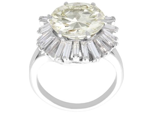 fig 4. A platinum cocktail ring featuring a large round central diamond enclosed by a sunburst halo of baguette-cut diamonds.