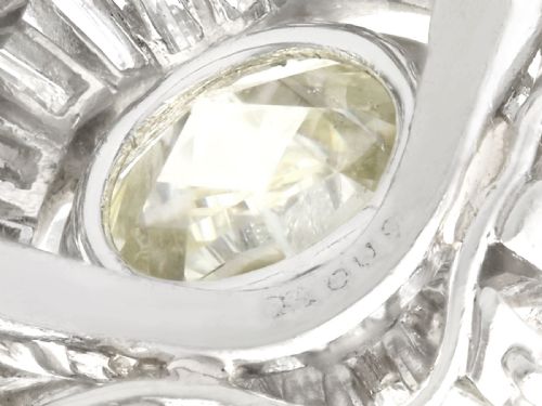 fig 5. A platinum cocktail ring featuring a large round central diamond enclosed by a sunburst halo of baguette-cut diamonds.