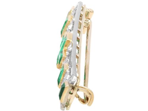 fig 2. An elongated 9ct yellow gold bar brooch featuring a central step-cut emerald flanked by geometric diamond-set panels and smaller emerald accents.