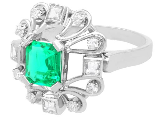 fig 2. An Art Deco 18ct white gold ring featuring a central octagonal green emerald surrounded by geometric diamond-set loop mounts.