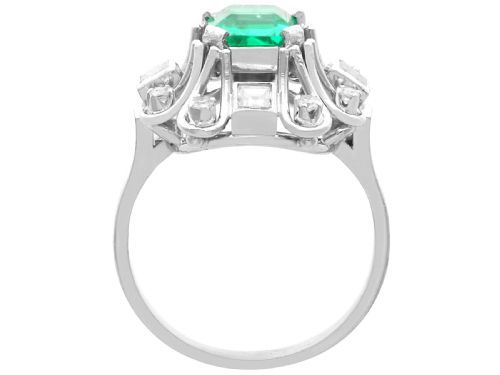fig 4. An Art Deco 18ct white gold ring featuring a central octagonal green emerald surrounded by geometric diamond-set loop mounts.