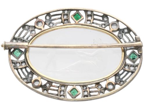 fig 5. An oval Victorian brooch featuring a reverse-carved rock crystal intaglio depicting Cupid and Psyche, bordered by rose-cut diamonds and square-cut emeralds set in gold and silver.