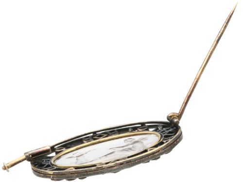 fig 6. An oval Victorian brooch featuring a reverse-carved rock crystal intaglio depicting Cupid and Psyche, bordered by rose-cut diamonds and square-cut emeralds set in gold and silver.