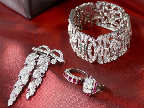 fig 2. An Art Deco 18ct white gold dress ring featuring a central cluster of old-cut diamonds flanked by channel-set calibre rubies.