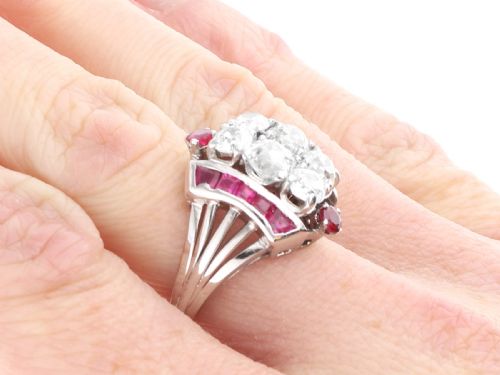 fig 8. An Art Deco 18ct white gold dress ring featuring a central cluster of old-cut diamonds flanked by channel-set calibre rubies.