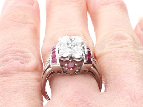 fig 9. An Art Deco 18ct white gold dress ring featuring a central cluster of old-cut diamonds flanked by channel-set calibre rubies.