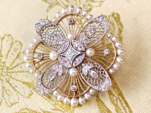 fig 3. An openwork circular Edwardian floral pendant brooch crafted in rose gold and platinum, set with central diamonds and a perimeter of natural pearls.