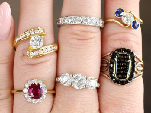fig 3. An 18ct yellow gold cluster ring featuring a central cushion cut red ruby framed by a halo of round diamonds.