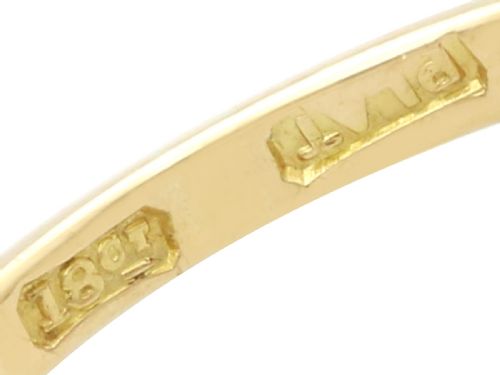 fig 7. An 18ct yellow gold cluster ring featuring a central cushion cut red ruby framed by a halo of round diamonds.