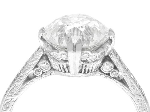 fig 2. A platinum solitaire ring featuring a large round diamond secured by multi-claw prongs on a hand-engraved decorative band.
