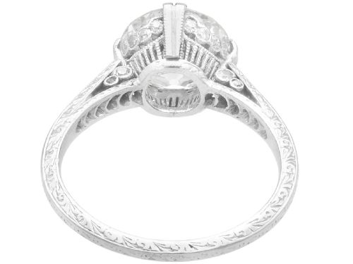 fig 3. A platinum solitaire ring featuring a large round diamond secured by multi-claw prongs on a hand-engraved decorative band.