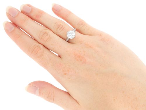 fig 5. A platinum solitaire ring featuring a large round diamond secured by multi-claw prongs on a hand-engraved decorative band.