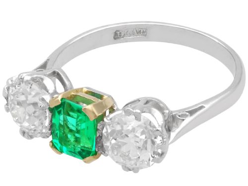 fig 3. An Art Deco platinum trilogy ring featuring a central emerald-cut green emerald flanked by two round diamonds.