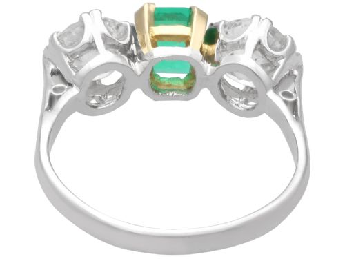 fig 4. An Art Deco platinum trilogy ring featuring a central emerald-cut green emerald flanked by two round diamonds.