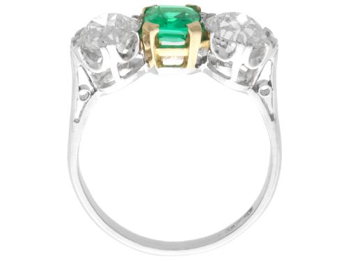 fig 5. An Art Deco platinum trilogy ring featuring a central emerald-cut green emerald flanked by two round diamonds.