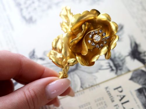 fig 2. An antique Victorian 22ct yellow gold floral brooch featuring sculpted petals, leaf details, and a central cluster of diamonds.